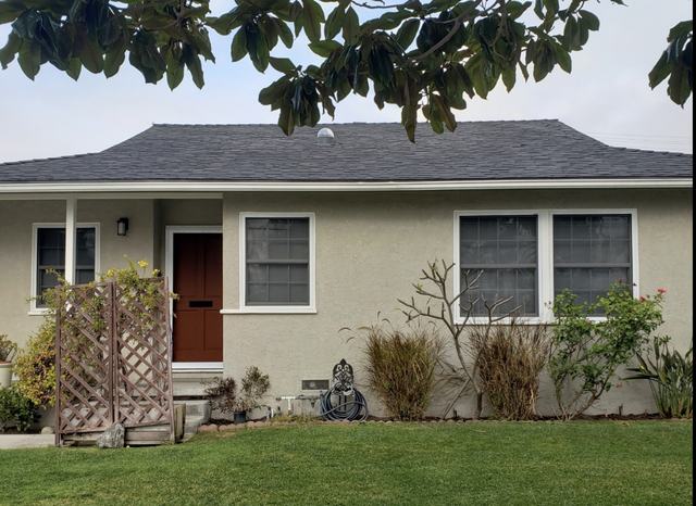 Single-story stucco home with a hinged security screen door and security screens on the front windows