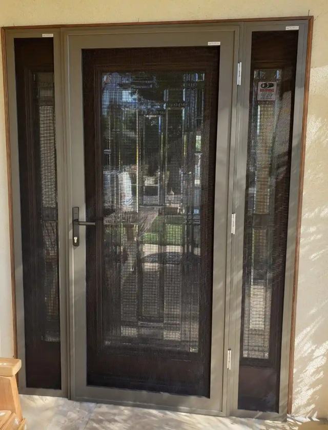Bronze hinged security screen door with a matching security screen sidelight on each side